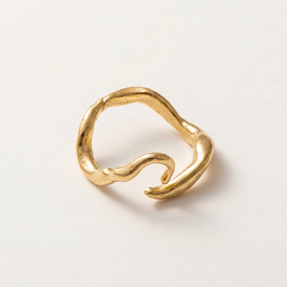 Gold ring with a wavy design on a white background