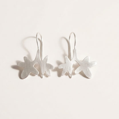 Pair of silver earrings on a light gray background