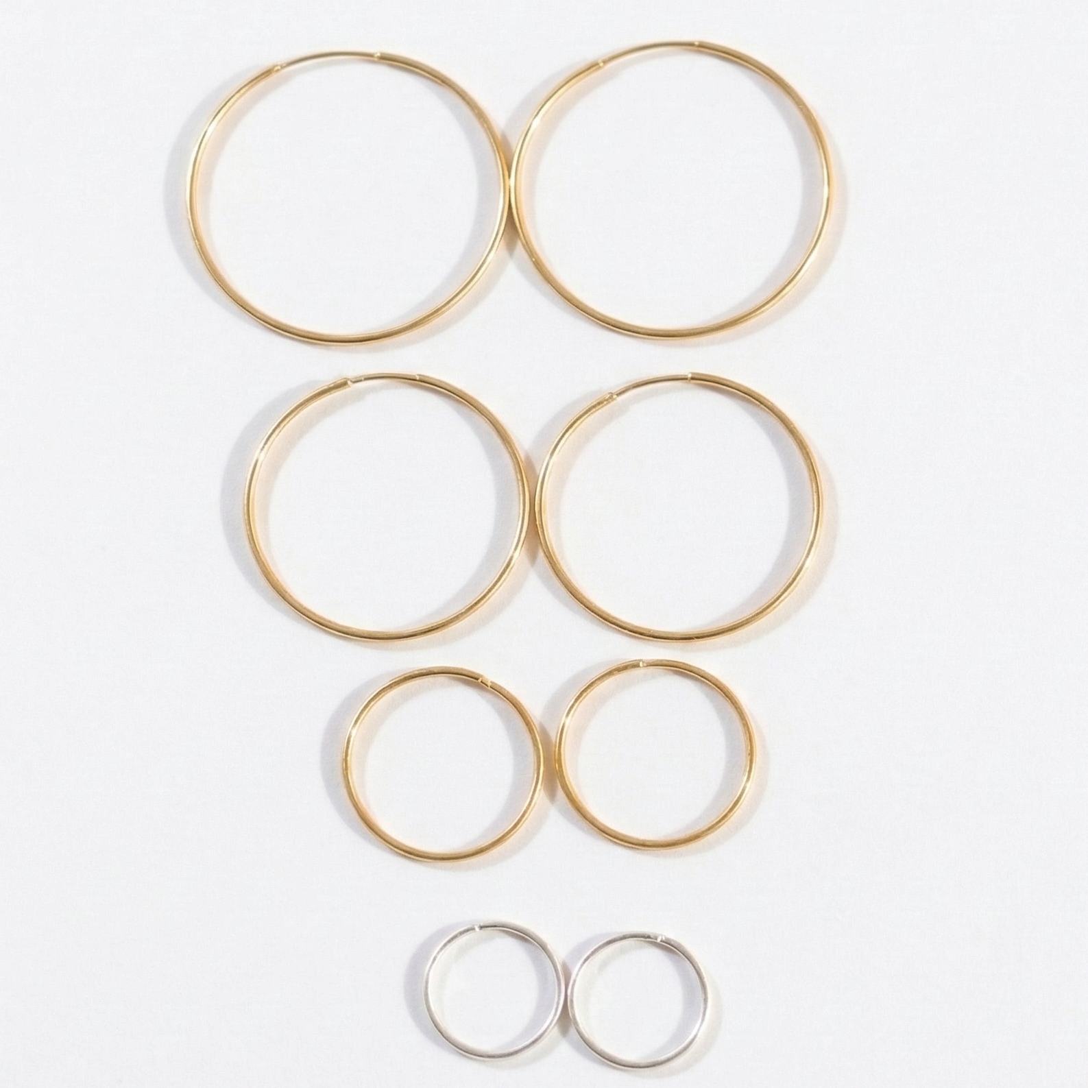 Set of gold hoop earrings on a white background