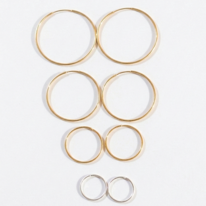 Set of gold hoop earrings on a white background