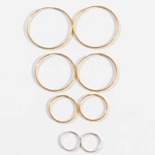 Set of gold hoop earrings on a white background