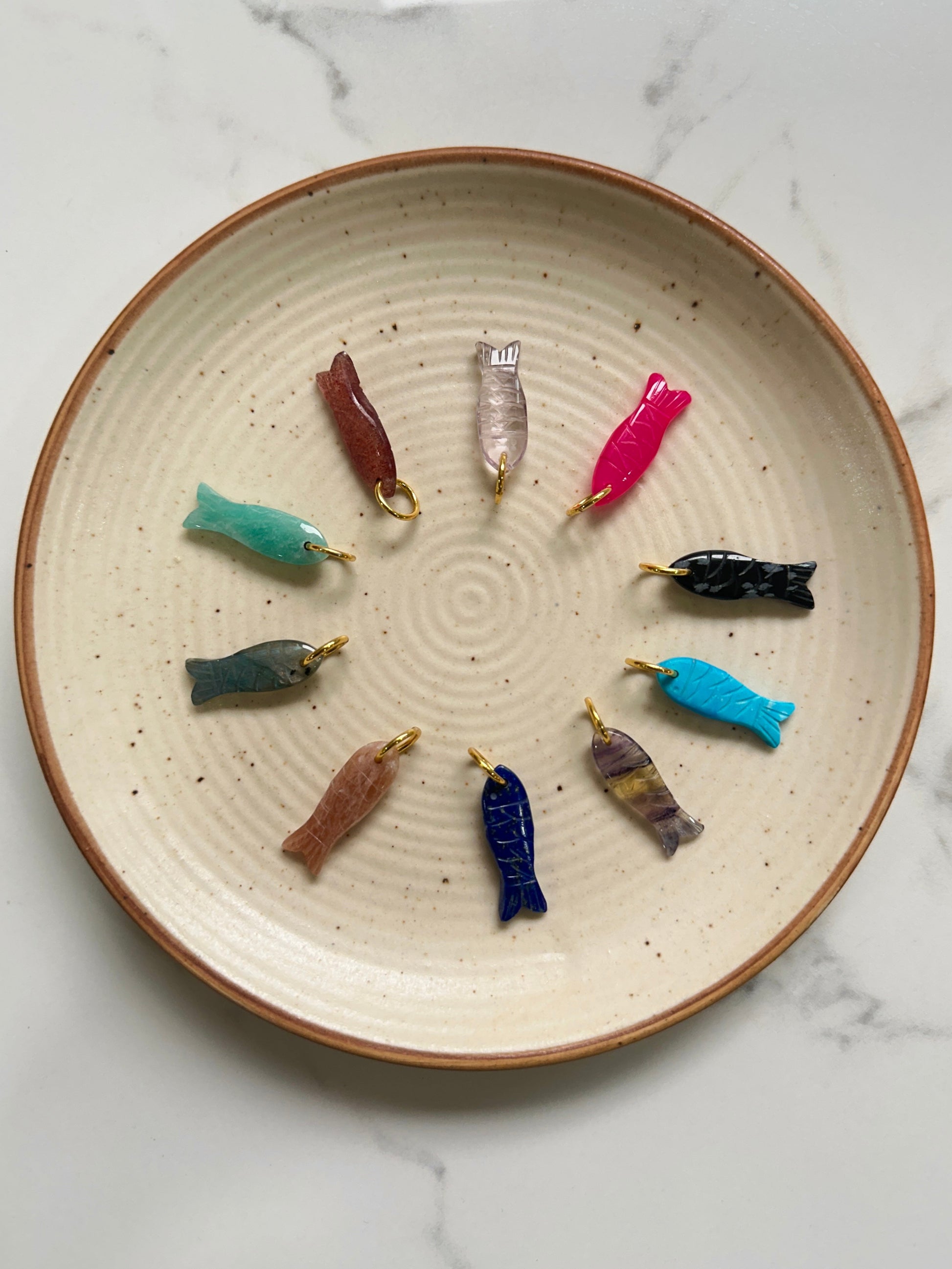 Colorful fishing lures on a ceramic plate with a marble background