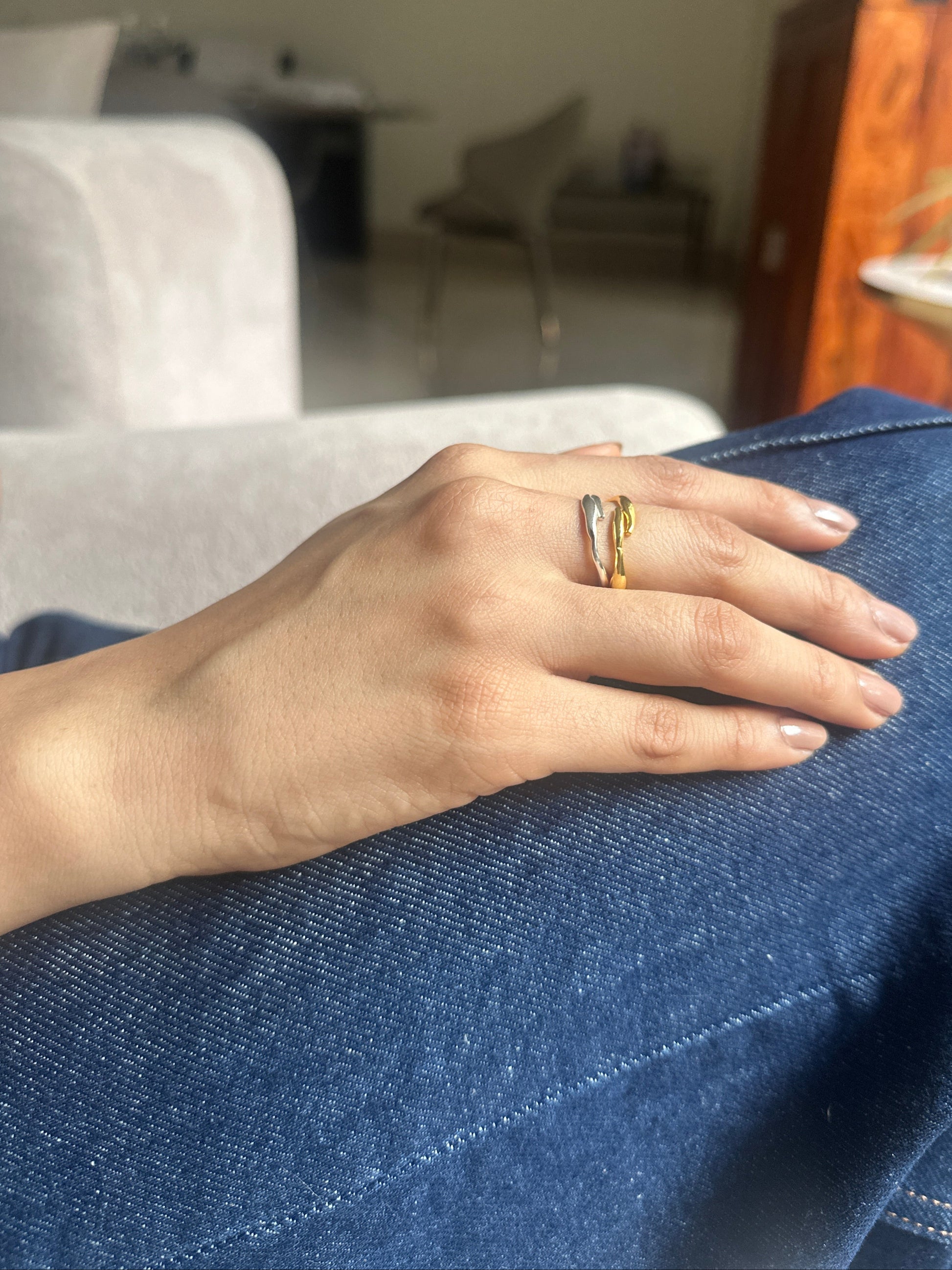 Hand with a gold ring on a blue denim background