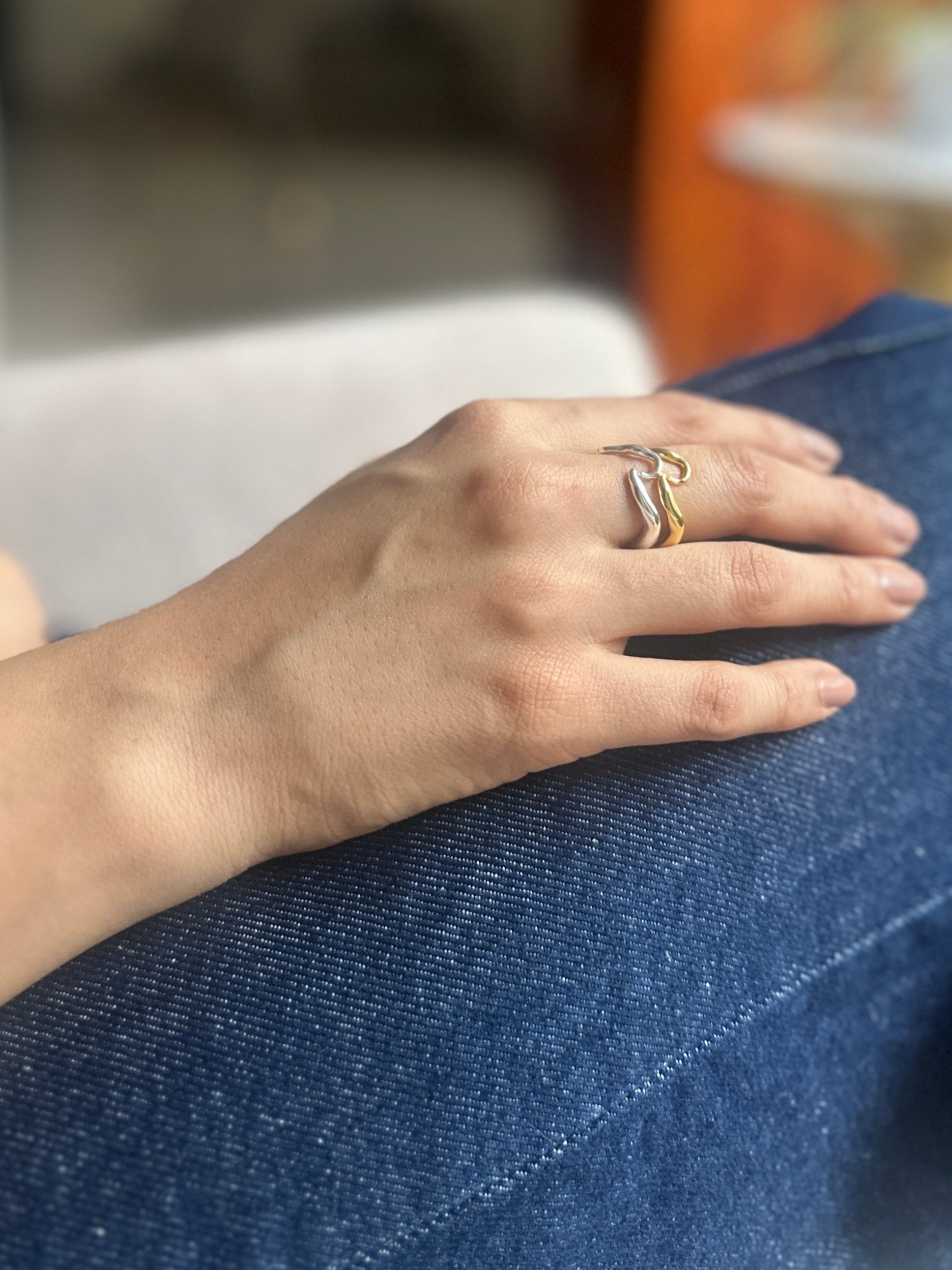 Close-up of a hand with a ring on a blue surface, blurred background