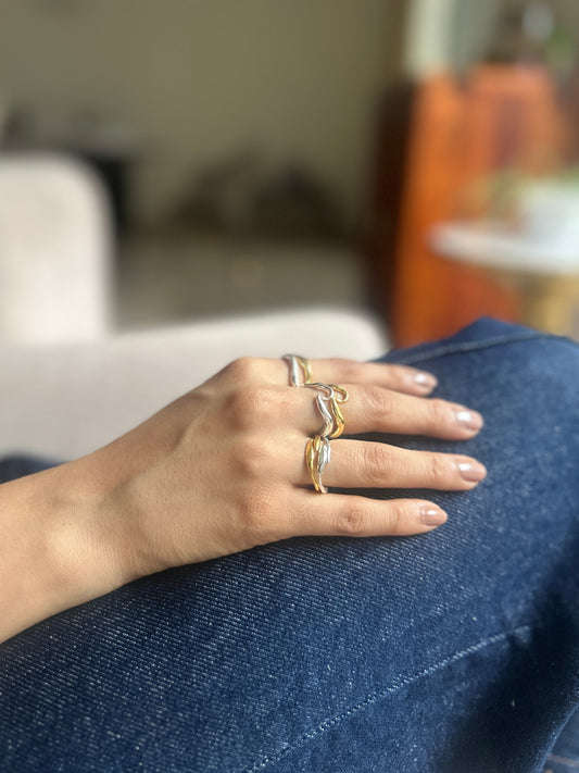 Hand with multiple rings on a blurred background