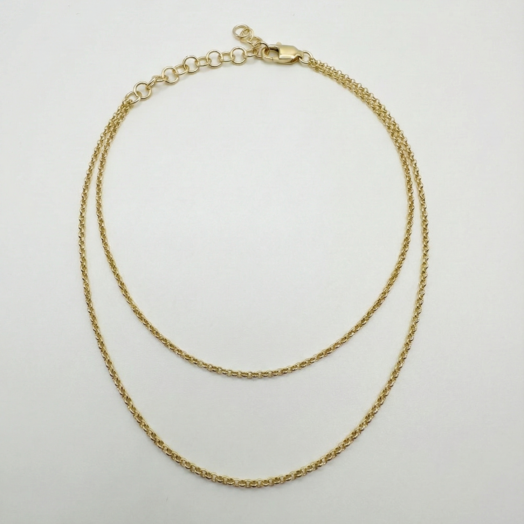 Gold anklet necklace on a light gray background