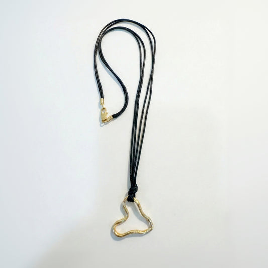 Necklace with black cord and gold heart-shaped clasp on a light gray background