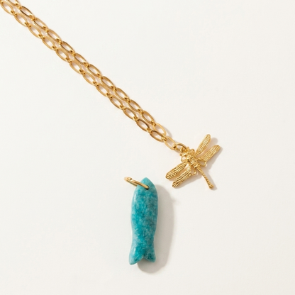 Gold necklace with a amazonite 
pendant and dragonfly charm on a white background