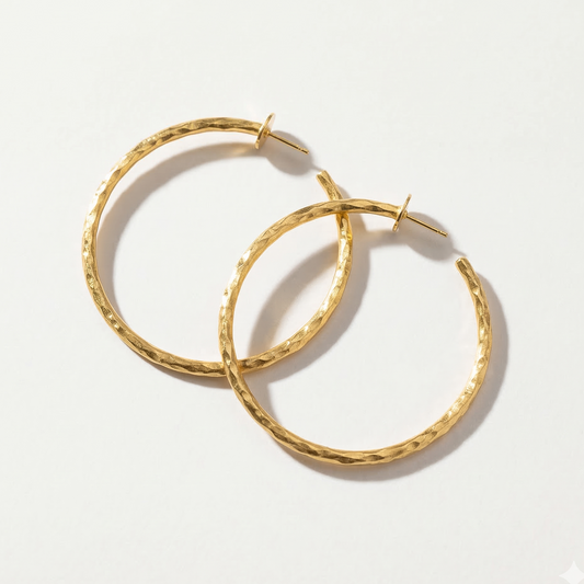 Gold hoop earrings on a light gray background