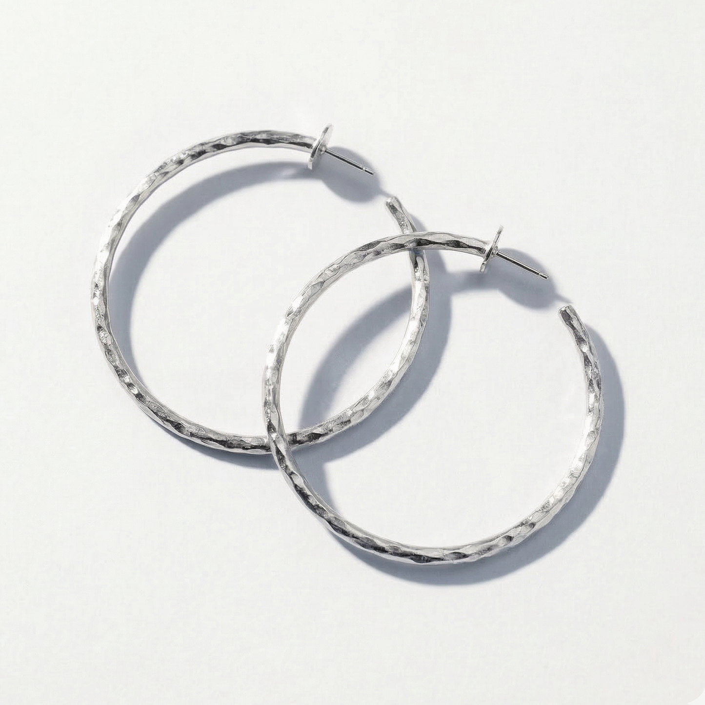 Pair of silver hoop earrings on a white background