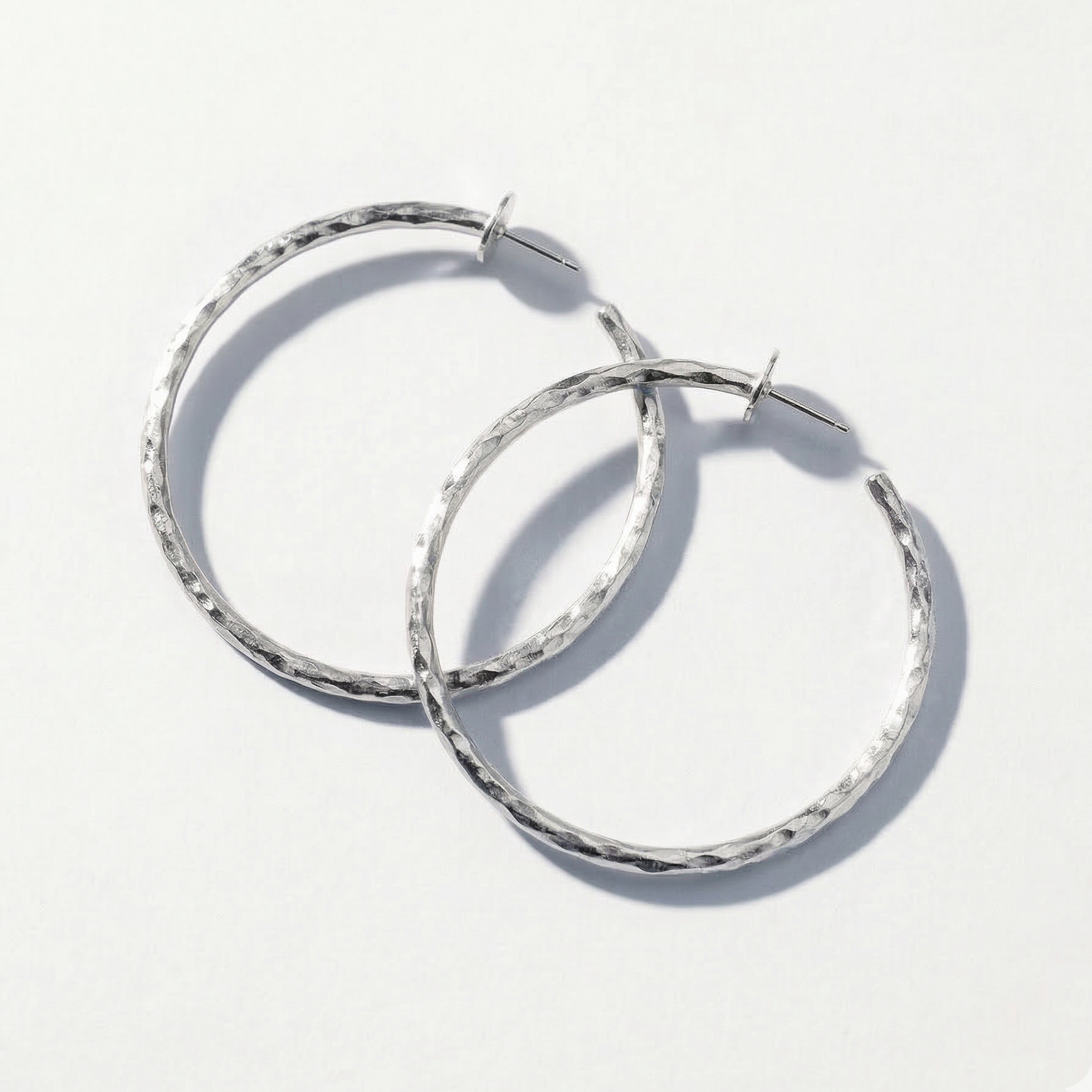 Pair of silver hoop earrings on a white background