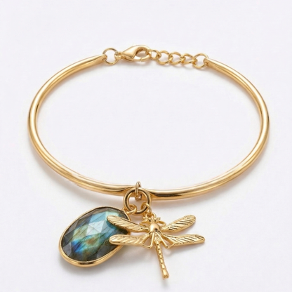 Gold bracelet with a dragonfly charm and gemstone on a white background