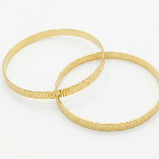 Two gold lined textured bangles on a white background