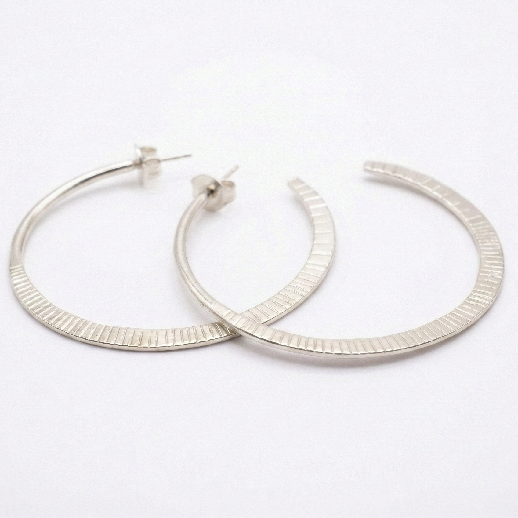 Pair of silver hoop earrings on a white background