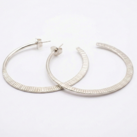 Pair of silver hoop earrings on a white background