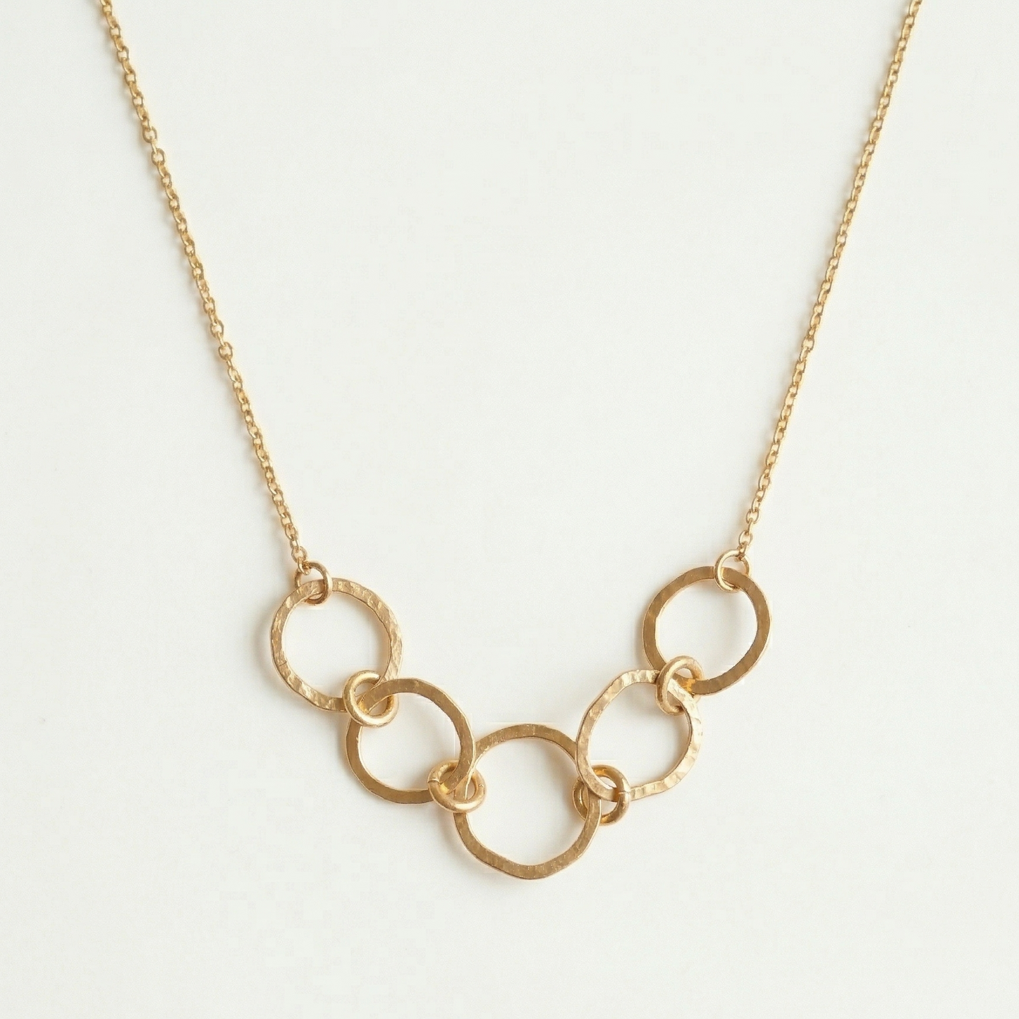 Gold chain necklace on a light gray background