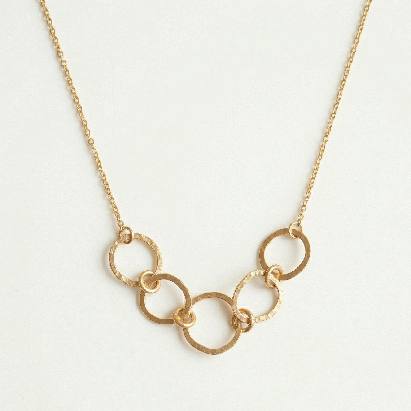 Gold chain necklace on a light gray background