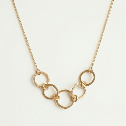 Gold chain necklace on a light gray background