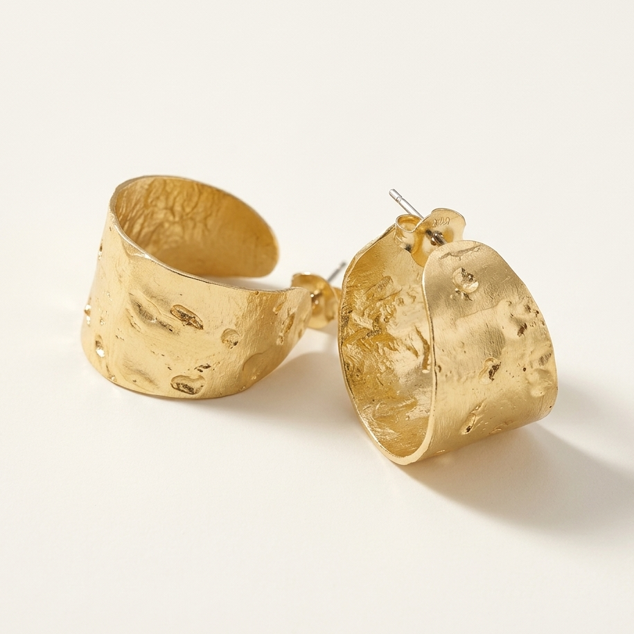 Gold hoop earrings on a light beige background