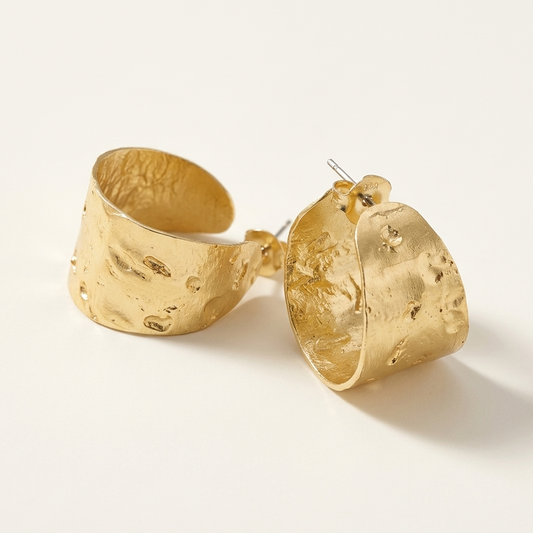 Gold hoop earrings on a light beige background