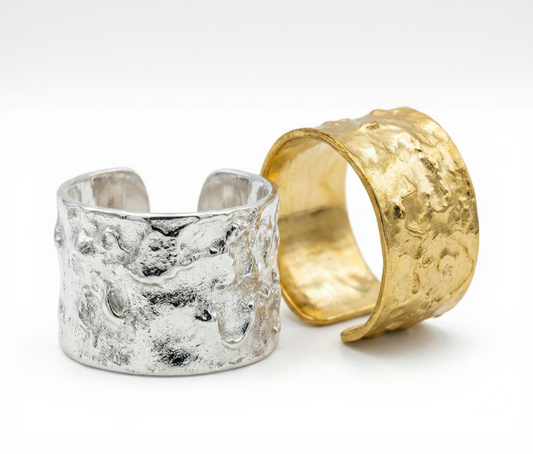 Two rings, one silver and one gold, on a white background