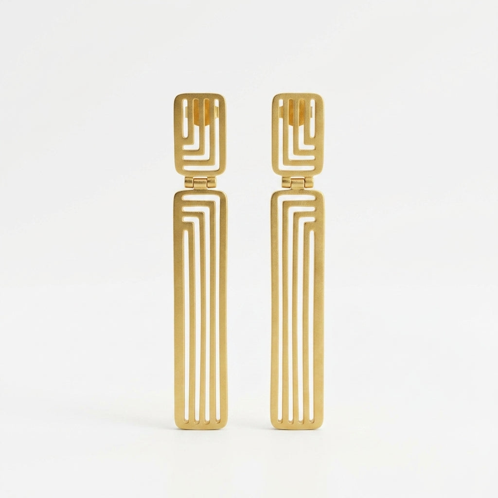 A pair of gold-toned geometric drop earrings with a rectangular top and a long, narrow vertical bar featuring parallel cutout lines, shown on a plain white background.