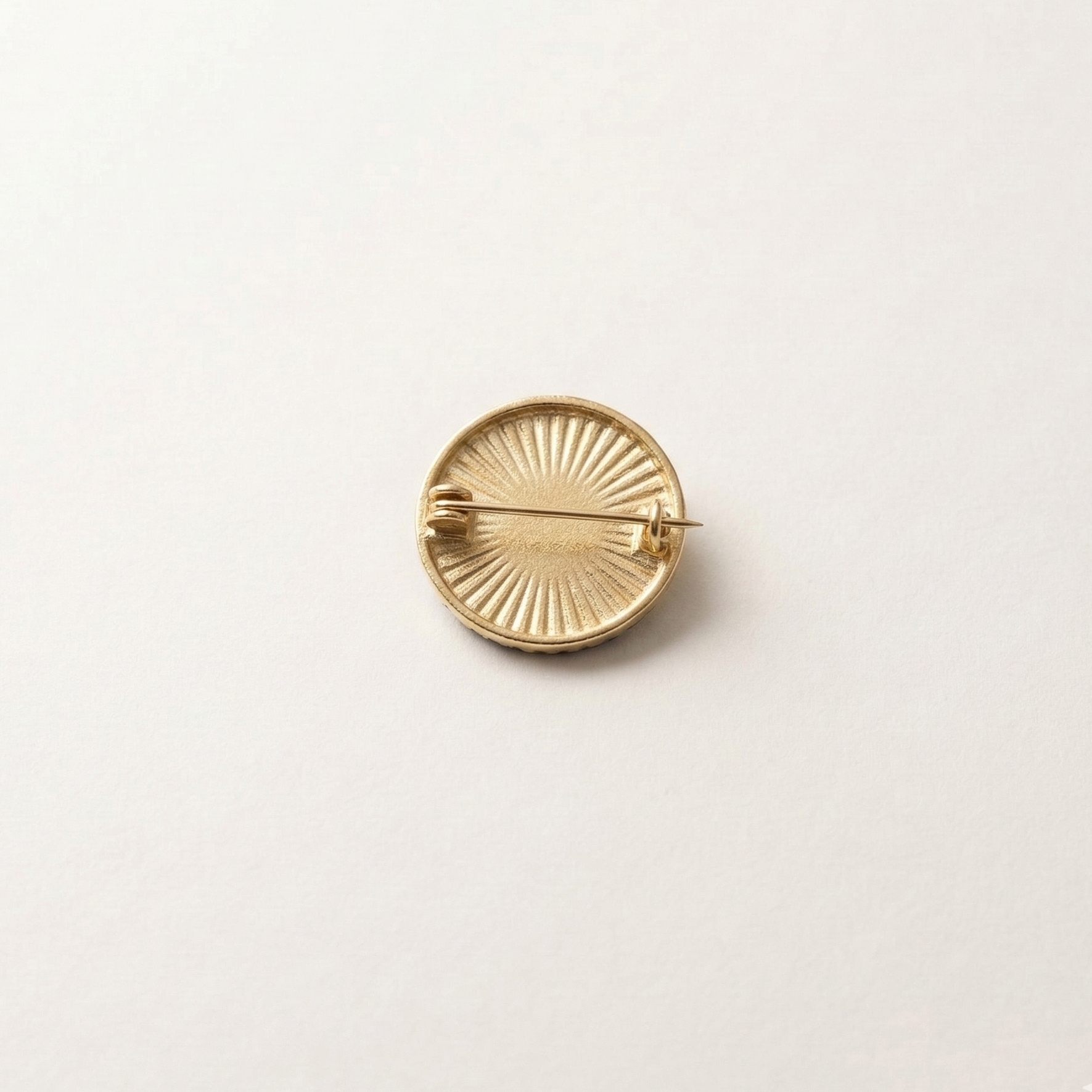 Gold brooch on a light beige background
