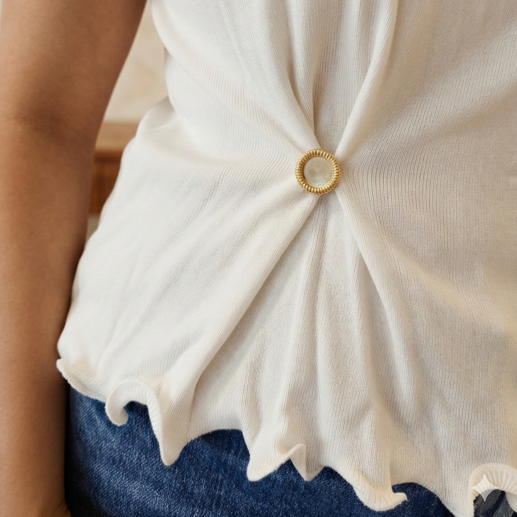 Mudra brooch on white top