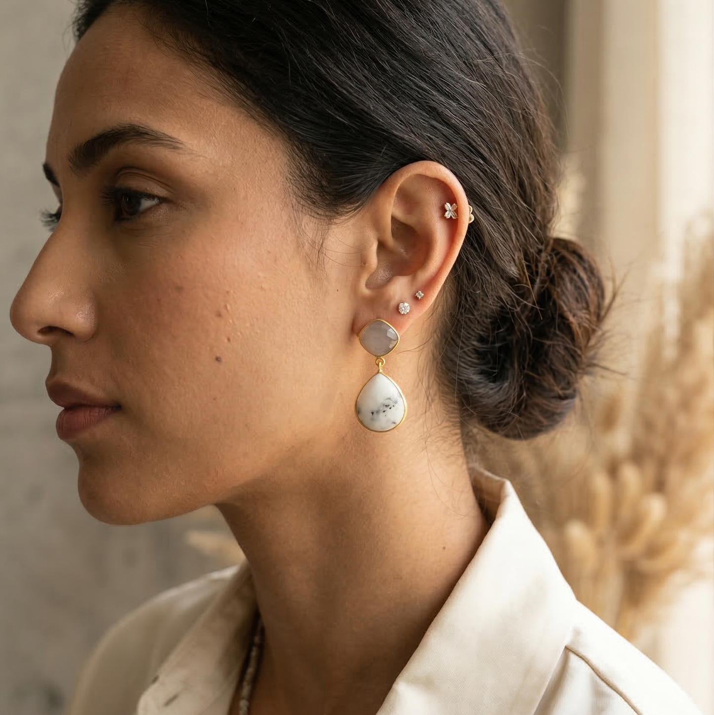 Woman wearing earrings with a neutral background