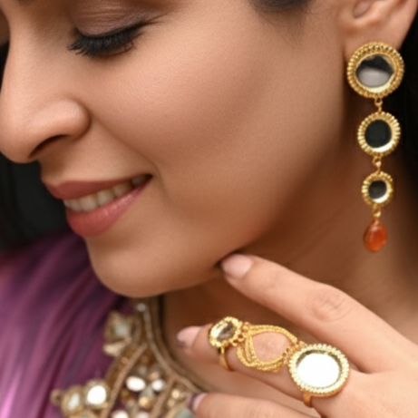 Woman wearing traditional jewelry including earrings, necklace, and ring, with a blurred background.
