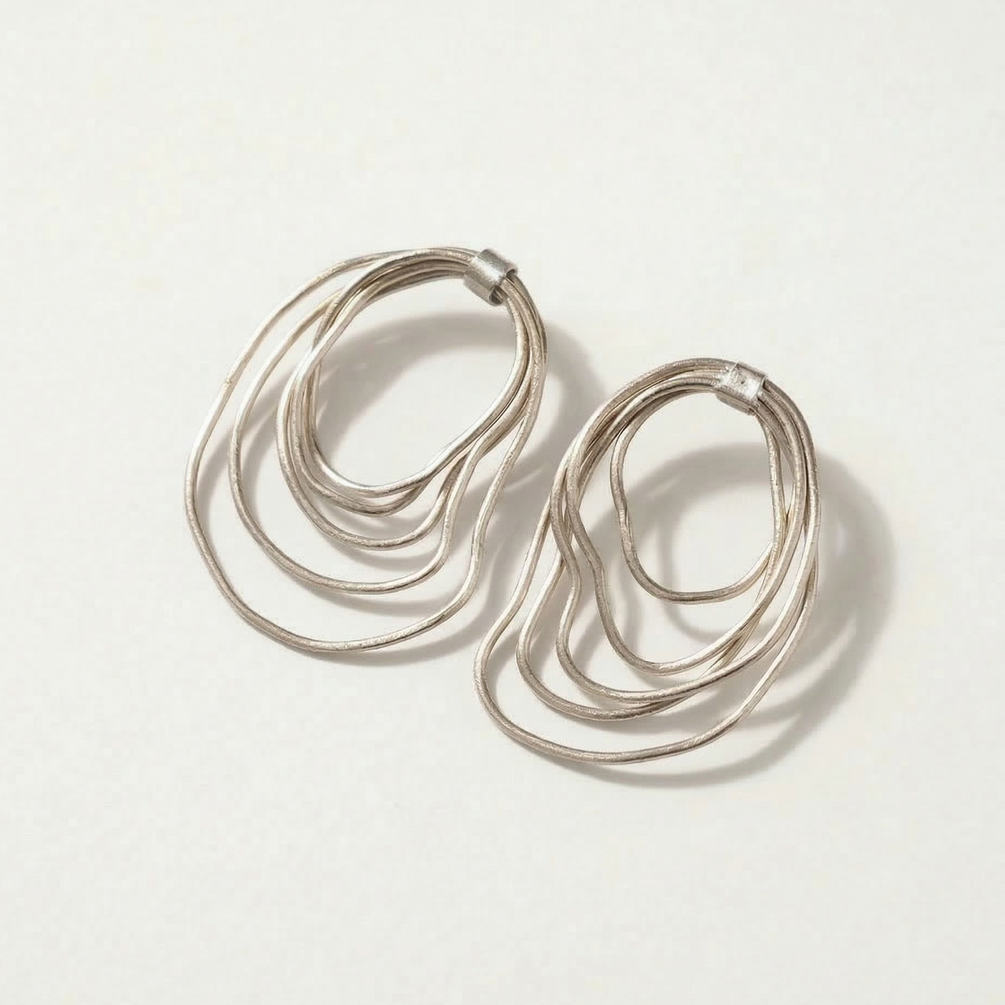 Silver hoop earrings on a light gray background