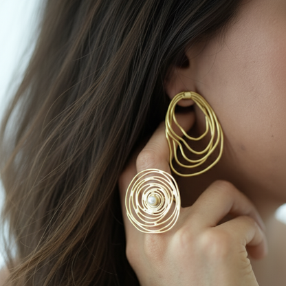 Close-up of a person wearing gold hoop earrings with a blurred background