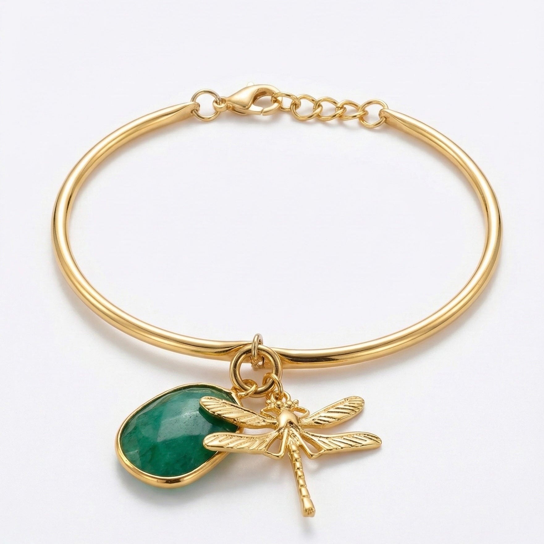 Gold bracelet with greenstone and dragonfly charm on a white background