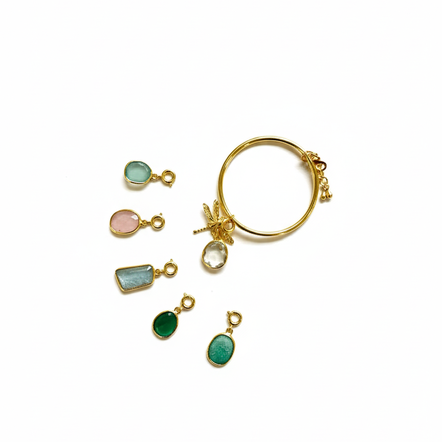 Gold dragonfly bracelet with various semi-precious stone charms on a white background