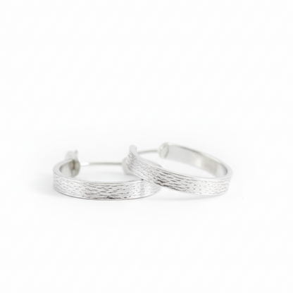Pair of silver hoop earrings on a white background