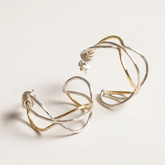 Pair of gold and silver hoop earrings on a white background