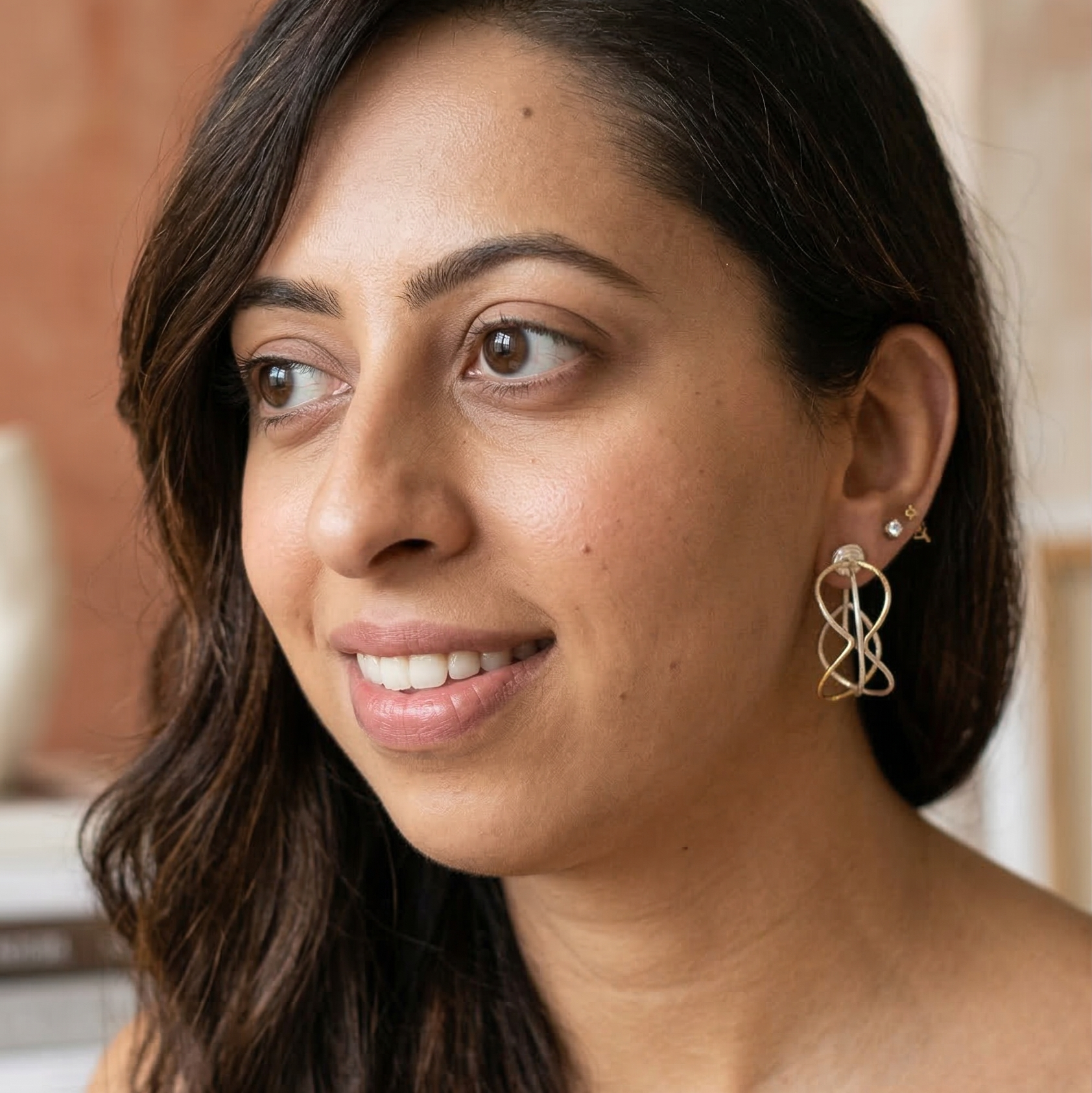 Woman wearing earrings with a neutral background