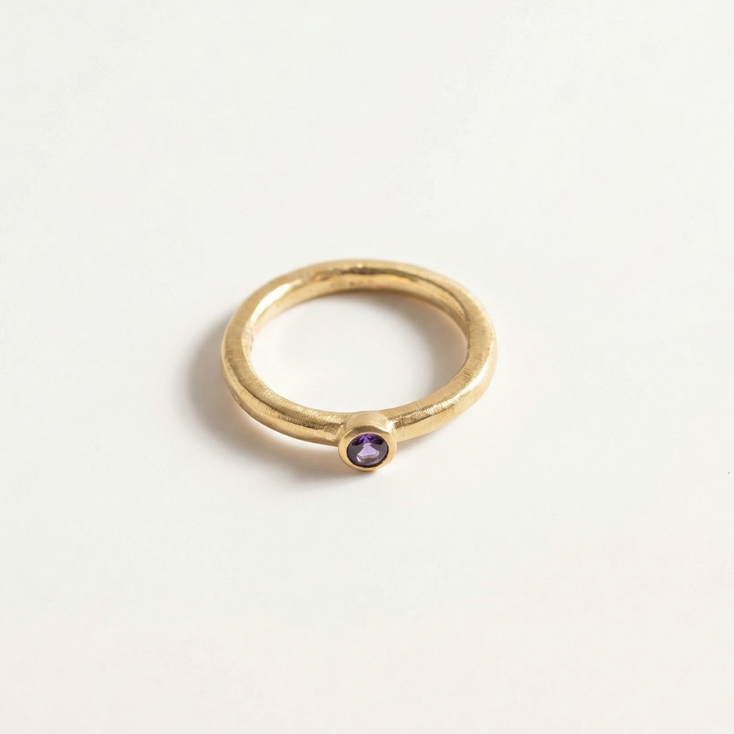 Gold ring with a iolite gemstone on a light gray background