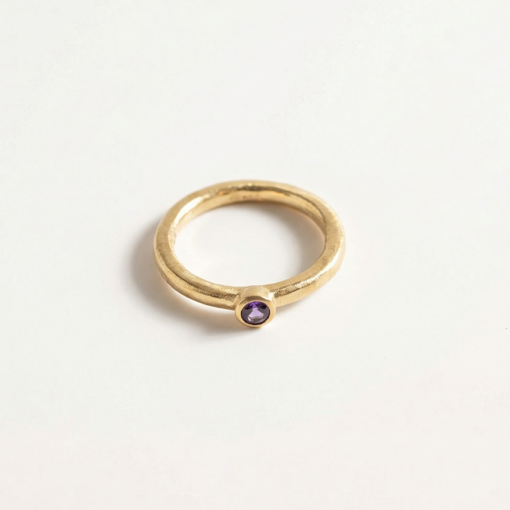 Gold ring with a iolite gemstone on a light gray background