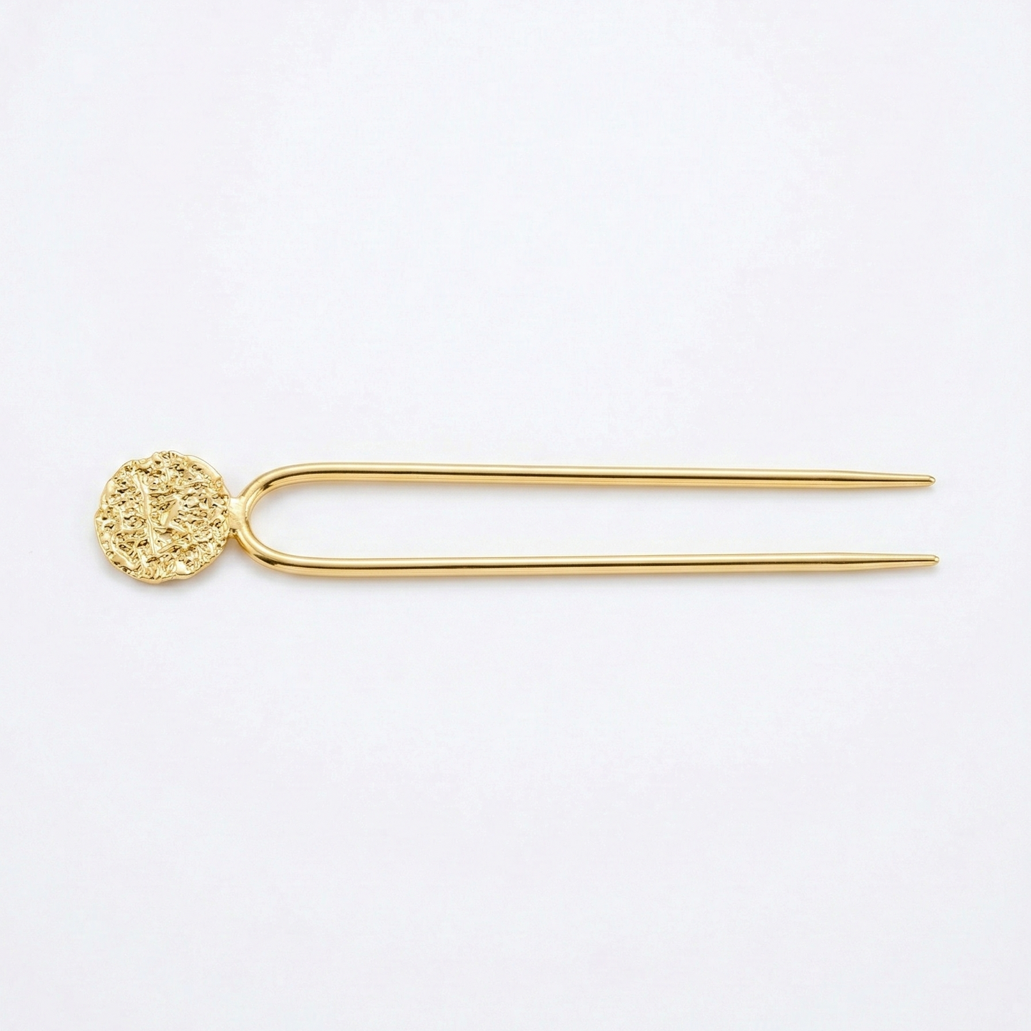 Gold hairpin with decorative end on a white background