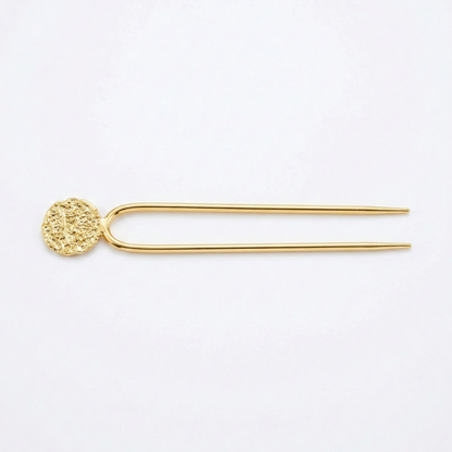 Gold hairpin with decorative end on a white background