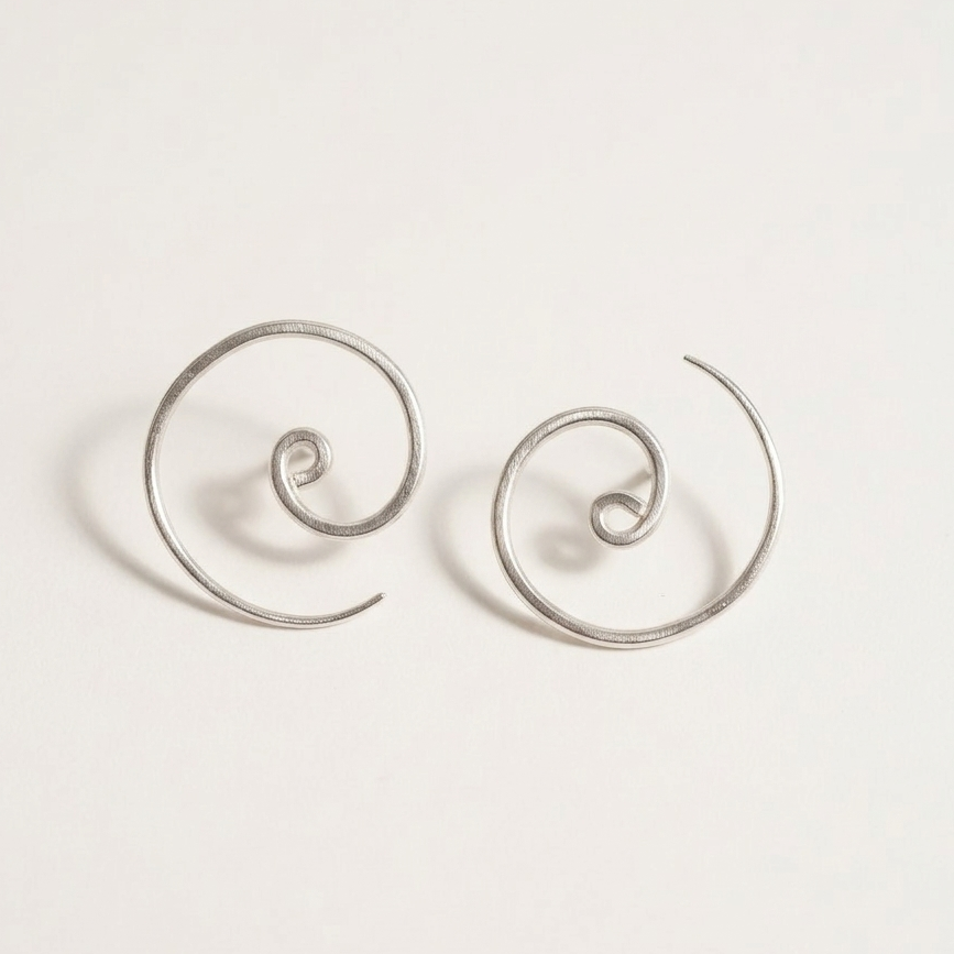 Pair of silver spiral earrings on a light gray background