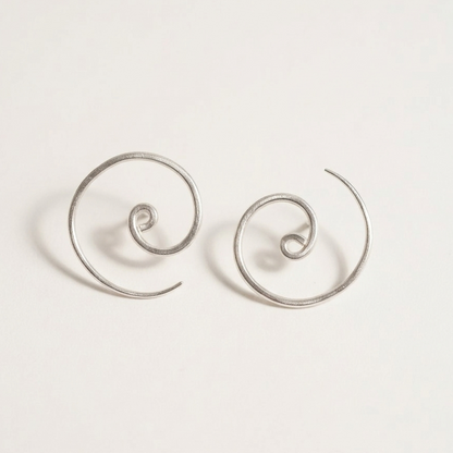 Pair of silver spiral earrings on a light gray background