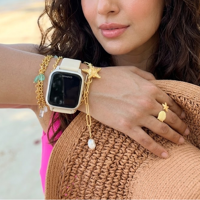 Woman on a beach wearing a gold starfish and pearl bracelet