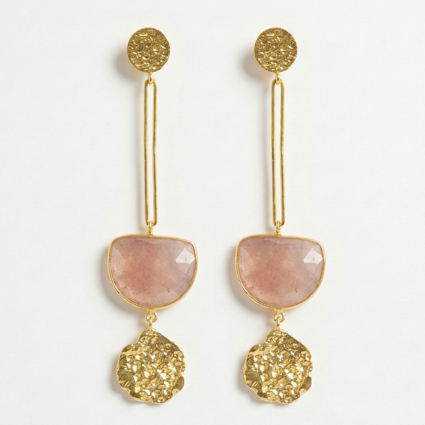 Gold and pink earrings on a white background