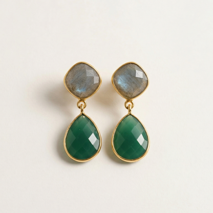 Pair of green teardrop earrings with gold accents on a light beige background