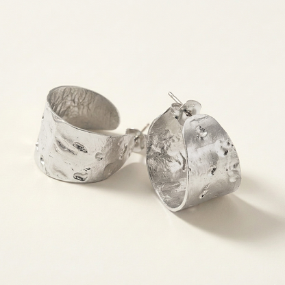 Pair of silver earrings on a light background